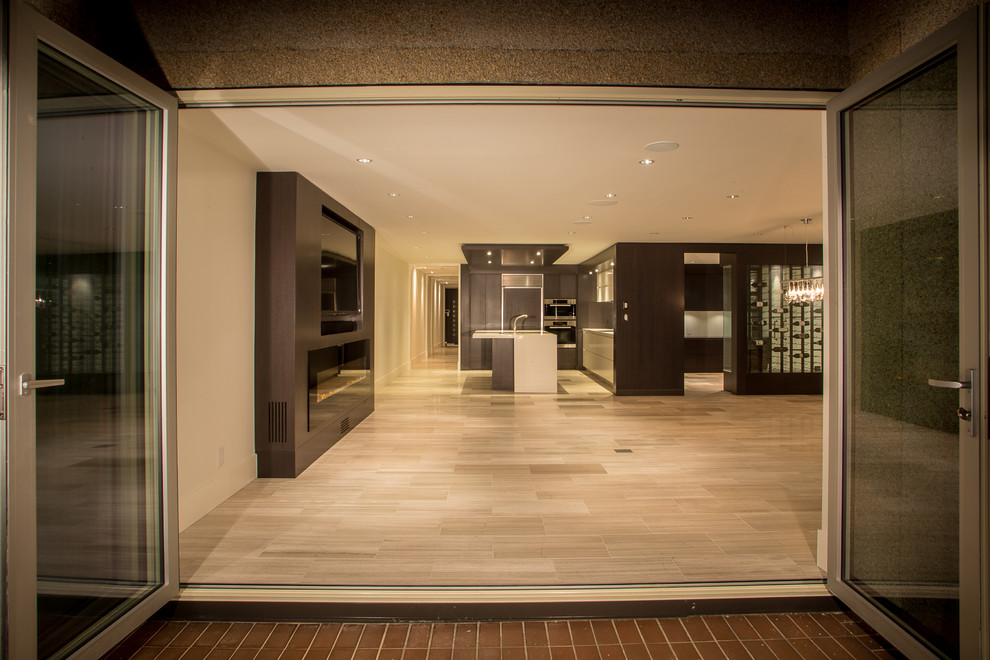 Imagen de salón abierto minimalista de tamaño medio con paredes blancas, suelo de madera clara y pared multimedia