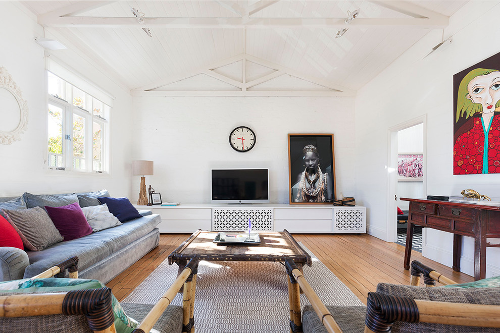 Inspiration för moderna separata vardagsrum, med vita väggar, ljust trägolv och en fristående TV