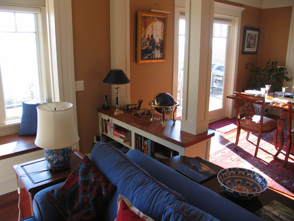 Cette photo montre un salon craftsman de taille moyenne et ouvert avec un mur multicolore, un sol en bois brun, une cheminée standard, un manteau de cheminée en pierre et un téléviseur d'angle.