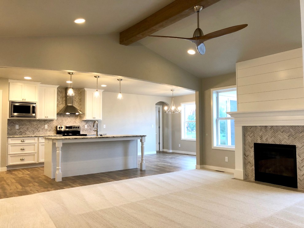 Cette photo montre un salon tendance de taille moyenne et ouvert avec un mur gris, moquette, une cheminée standard, un manteau de cheminée en carrelage et un sol beige.