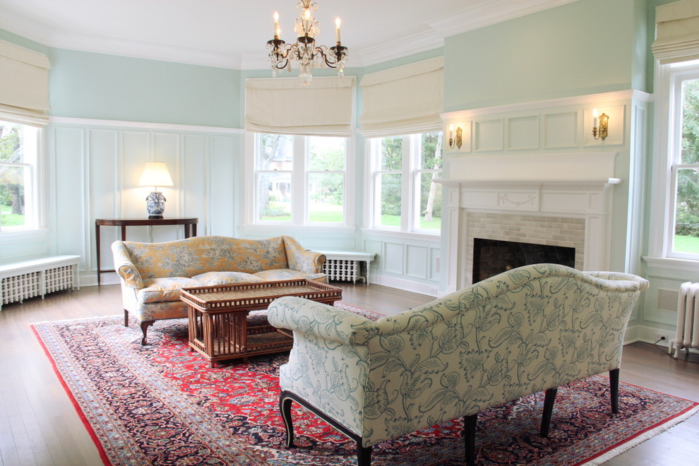 На фото: гостиная комната в викторианском стиле с синими стенами и фасадом камина из плитки с