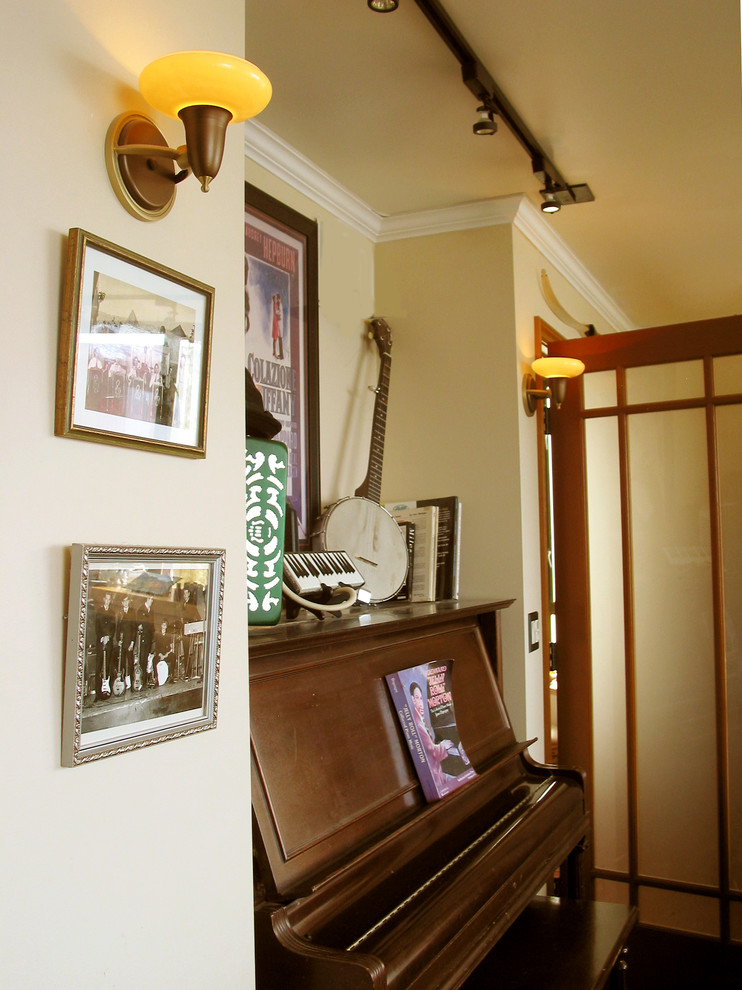 Bild på ett litet amerikanskt allrum med öppen planlösning, med flerfärgade väggar, mellanmörkt trägolv och ett musikrum