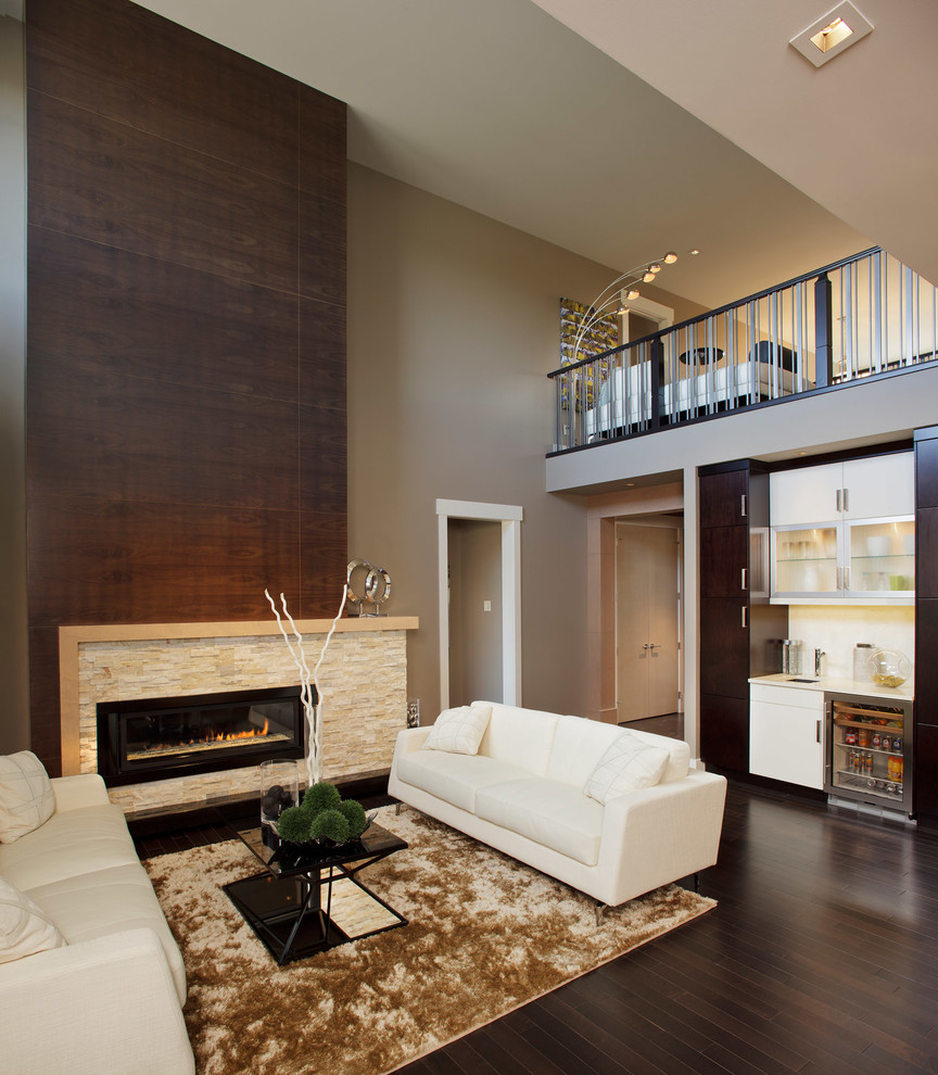 На фото: открытая гостиная комната среднего размера в современном стиле с коричневыми стенами, темным паркетным полом, горизонтальным камином и фасадом камина из камня без телевизора
