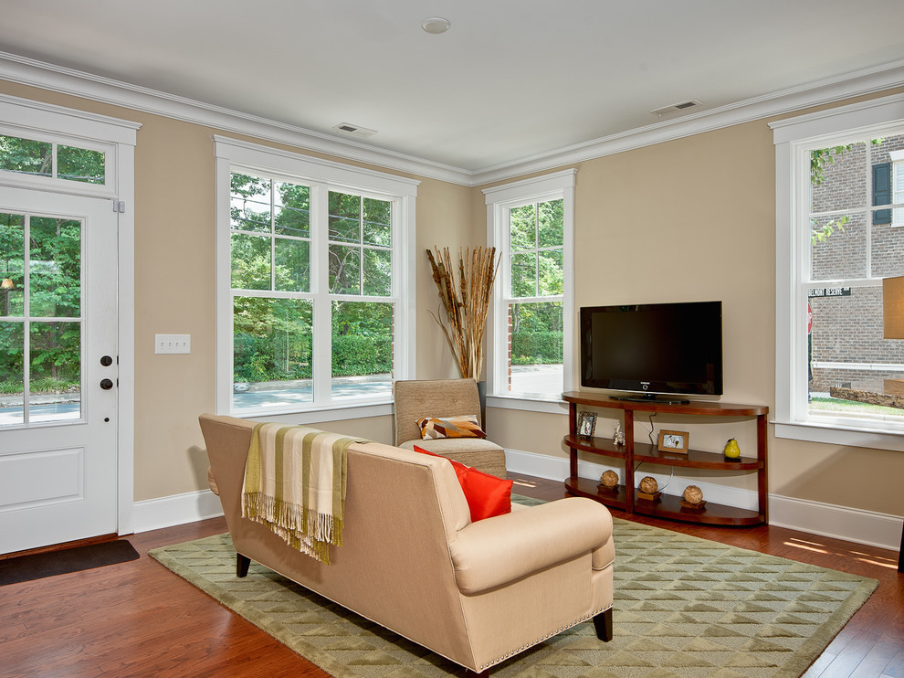 Immagine di un piccolo soggiorno classico aperto con pareti beige, pavimento in legno massello medio, nessun camino, TV a parete e pavimento marrone
