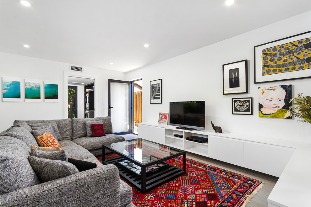Idee per un soggiorno contemporaneo chiuso con pareti bianche, TV autoportante e pavimento grigio