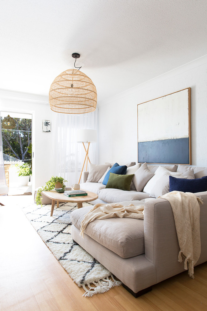 Immagine di un soggiorno costiero con pareti bianche, pavimento in legno massello medio e pavimento marrone