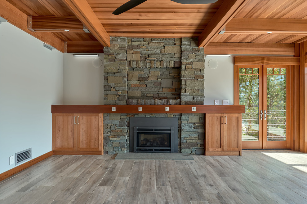 サクラメントにある高級な中くらいなトランジショナルスタイルのおしゃれな独立型リビング (グレーの壁、磁器タイルの床、標準型暖炉、石材の暖炉まわり、グレーの床) の写真