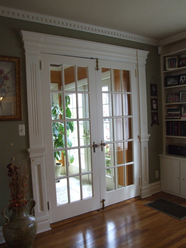 Bild på ett mellanstort vintage separat vardagsrum, med gröna väggar, mellanmörkt trägolv, ett bibliotek, en standard öppen spis, en spiselkrans i trä och brunt golv