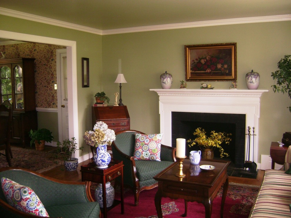 Cette photo montre un salon chic avec une salle de réception, un mur vert, parquet clair et une cheminée standard.