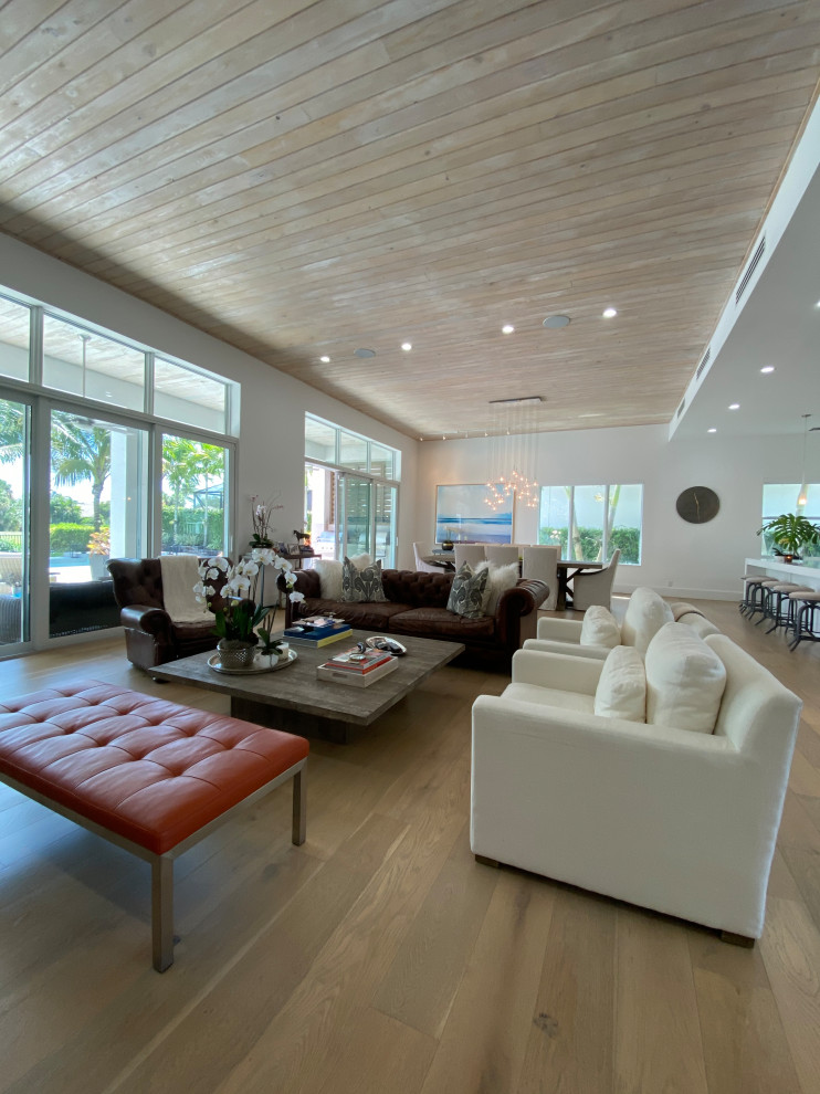 Foto di un grande soggiorno minimalista aperto con sala formale, pareti bianche, parquet chiaro, nessun camino, TV a parete, pavimento grigio e soffitto in legno