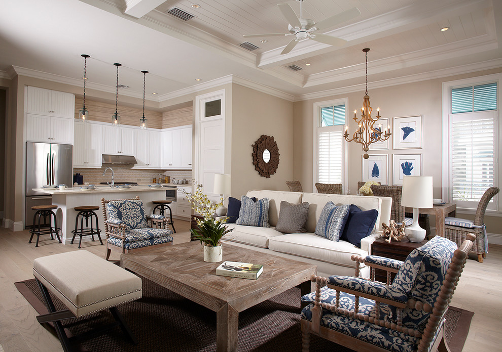 Example of a beach style open concept light wood floor and gray floor living room design in Miami with beige walls