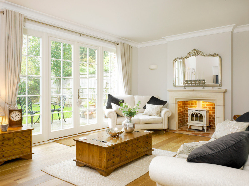 Immagine di un soggiorno classico con pareti grigie e stufa a legna