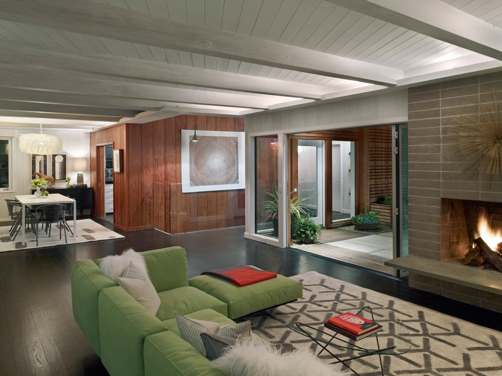 Стильный дизайн: большая парадная, открытая гостиная комната в стиле модернизм с фасадом камина из бетона, темным паркетным полом и стандартным камином без телевизора - последний тренд
