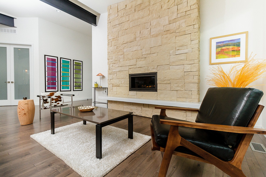 Design ideas for a large midcentury open plan living room in Denver with white walls, dark hardwood flooring, a standard fireplace and a stone fireplace surround.