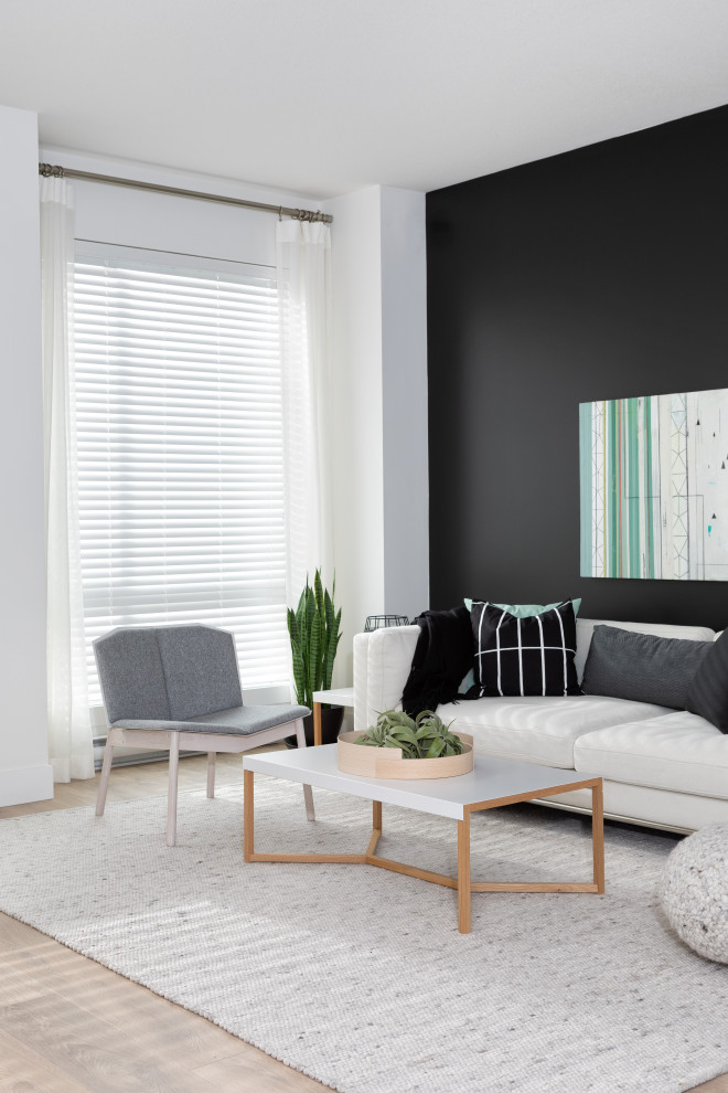 Photo of a medium sized scandi open plan living room in Vancouver with black walls, laminate floors, a built-in media unit and brown floors.