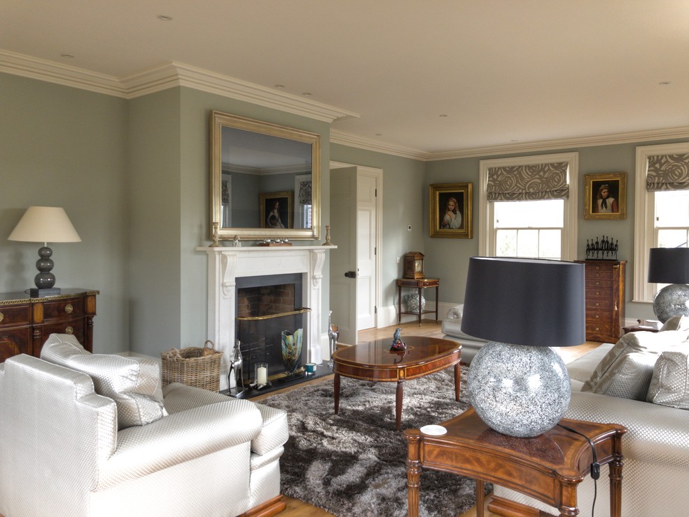 Пример оригинального дизайна: большая изолированная гостиная комната в классическом стиле с паркетным полом среднего тона, стандартным камином, фасадом камина из камня, синими стенами и коричневым полом