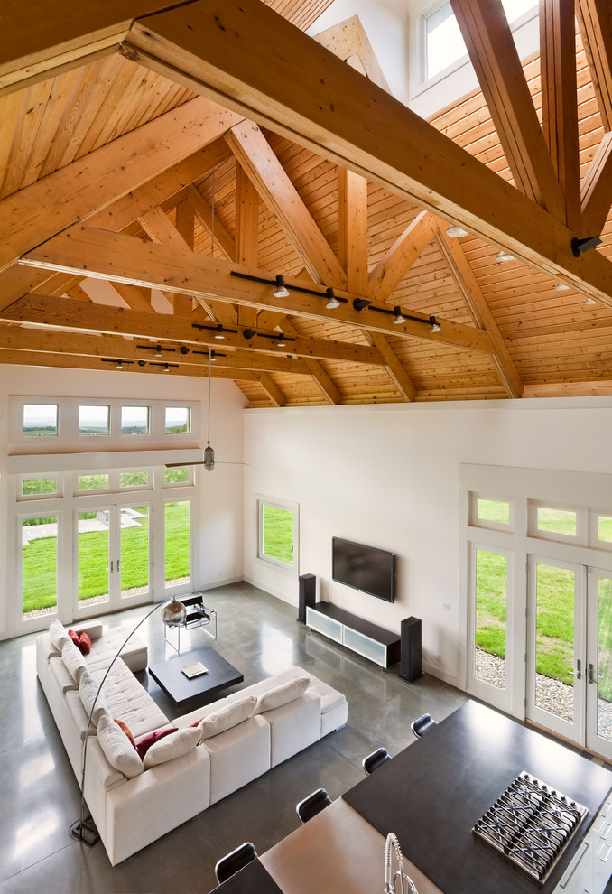 This is an example of a contemporary living room in New York with concrete flooring and feature lighting.