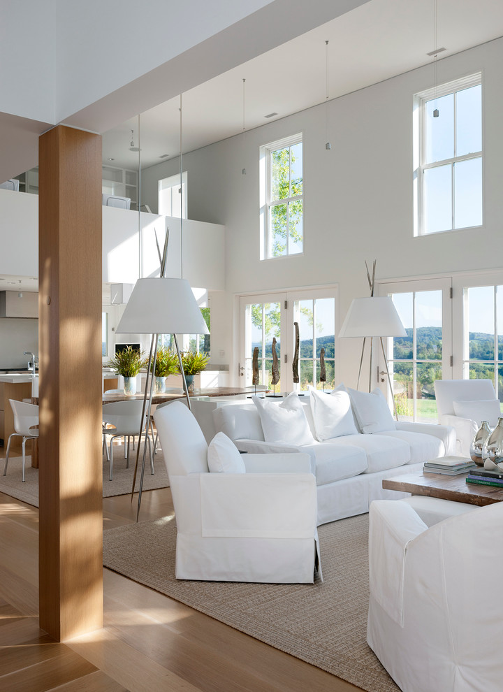 Ejemplo de salón para visitas campestre grande sin chimenea y televisor con paredes blancas y suelo de madera clara