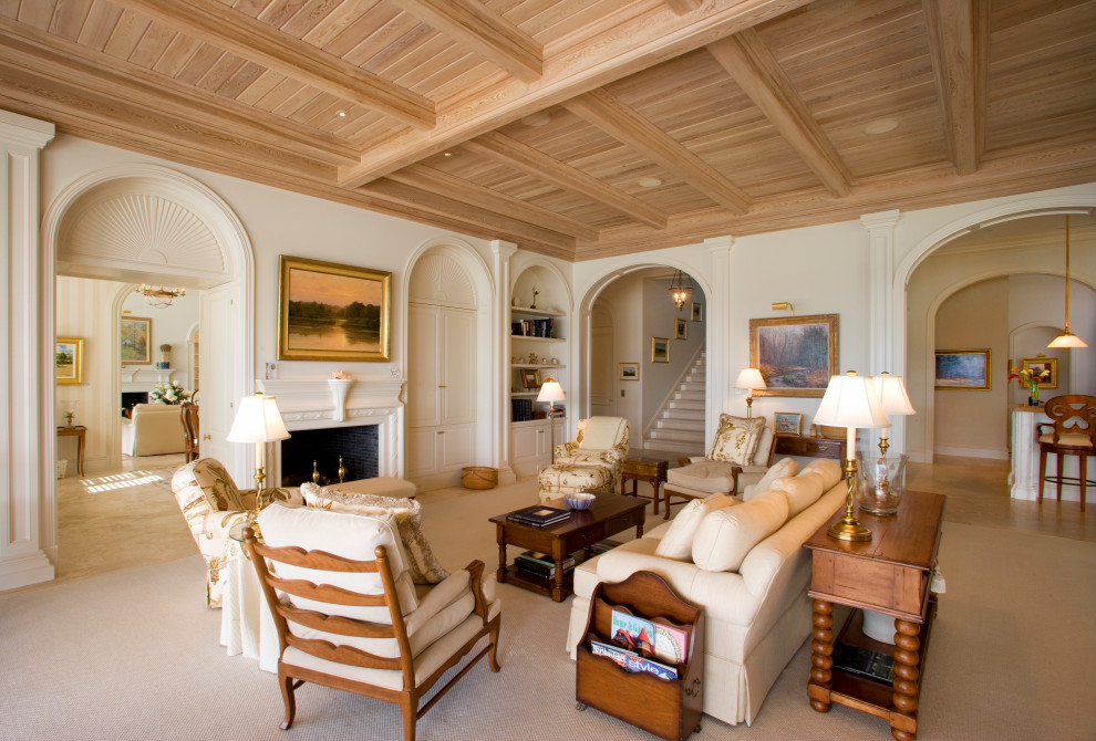 Esempio di un soggiorno tropicale chiuso con pareti bianche, moquette, camino classico, pavimento beige, travi a vista e soffitto in legno