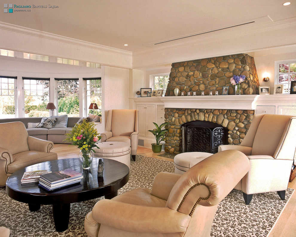 Immagine di un soggiorno stile marinaro con sala formale, pareti bianche, parquet chiaro, camino classico e cornice del camino in pietra