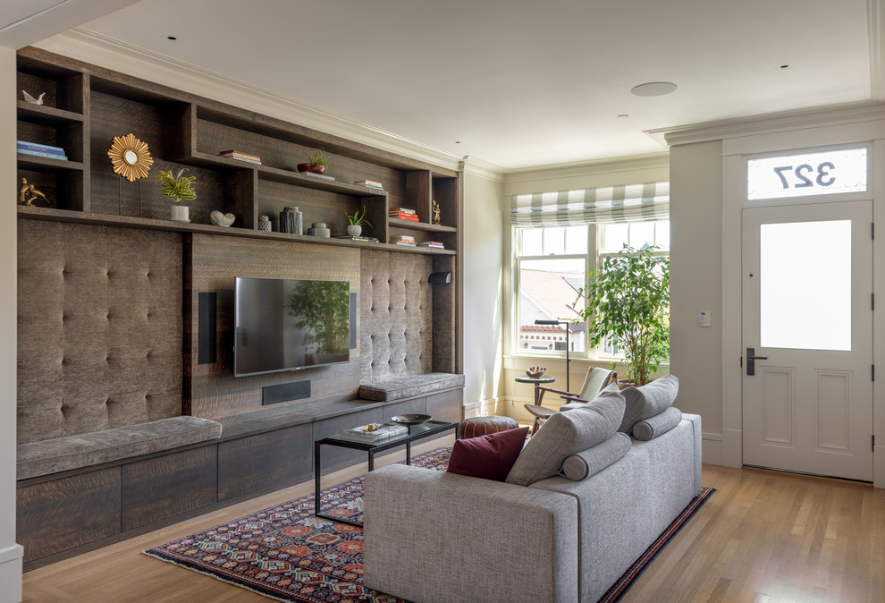 Esempio di un soggiorno classico aperto con TV a parete, pareti beige, pavimento in legno massello medio e pavimento marrone