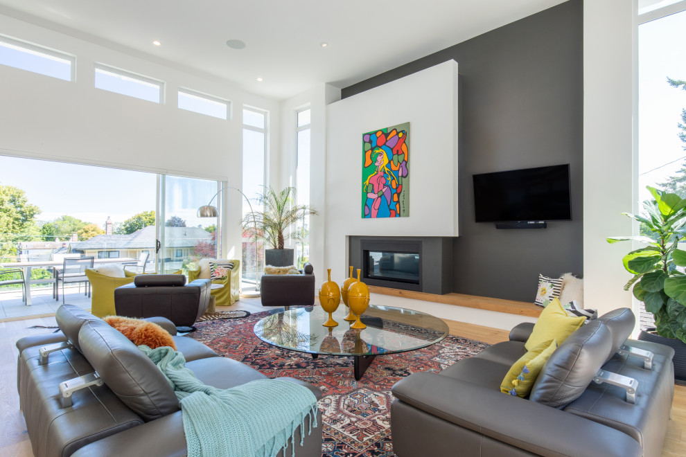 Esempio di un soggiorno contemporaneo aperto con pareti grigie, pavimento in legno massello medio, camino lineare Ribbon, TV a parete e pavimento marrone