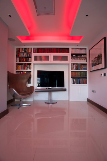 На фото: изолированная гостиная комната среднего размера в современном стиле с белыми стенами, полом из керамогранита и отдельно стоящим телевизором