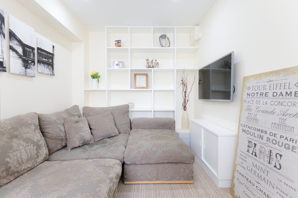 Esempio di un piccolo soggiorno tradizionale chiuso con pareti beige, moquette e TV a parete