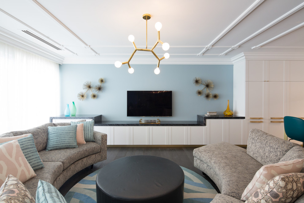 Стильный дизайн: гостиная комната в современном стиле с синими стенами, темным паркетным полом, телевизором на стене и коричневым полом - последний тренд