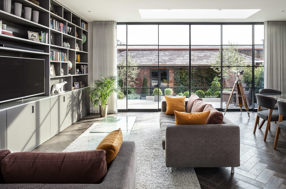 Mittelgroßes Modernes Wohnzimmer mit weißer Wandfarbe, hellem Holzboden, braunem Boden und freistehendem TV in London