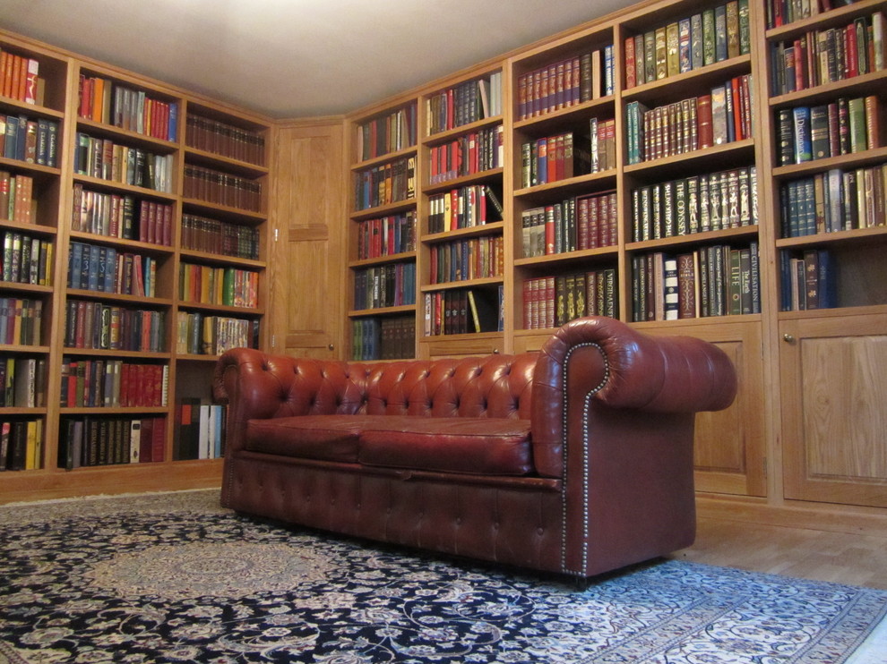 Modelo de biblioteca en casa cerrada bohemia de tamaño medio sin chimenea y televisor con paredes blancas y suelo de madera clara