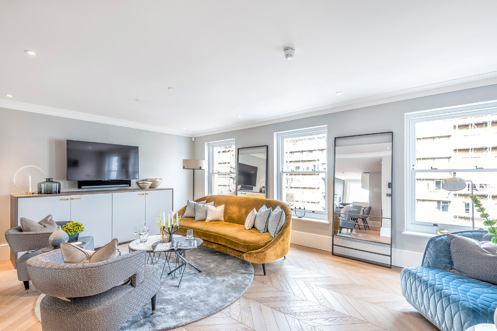 Offenes Klassisches Wohnzimmer mit grauer Wandfarbe, braunem Holzboden, TV-Wand und braunem Boden in London
