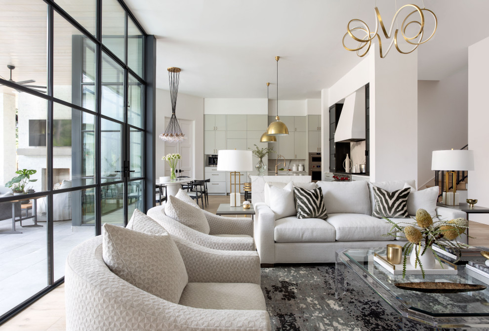 Esempio di un ampio soggiorno chic aperto con pareti bianche, parquet chiaro, camino classico, TV a parete e pavimento marrone