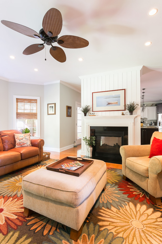 Repräsentatives, Fernseherloses Wohnzimmer mit weißer Wandfarbe, braunem Holzboden, Kamin und braunem Boden in Charleston