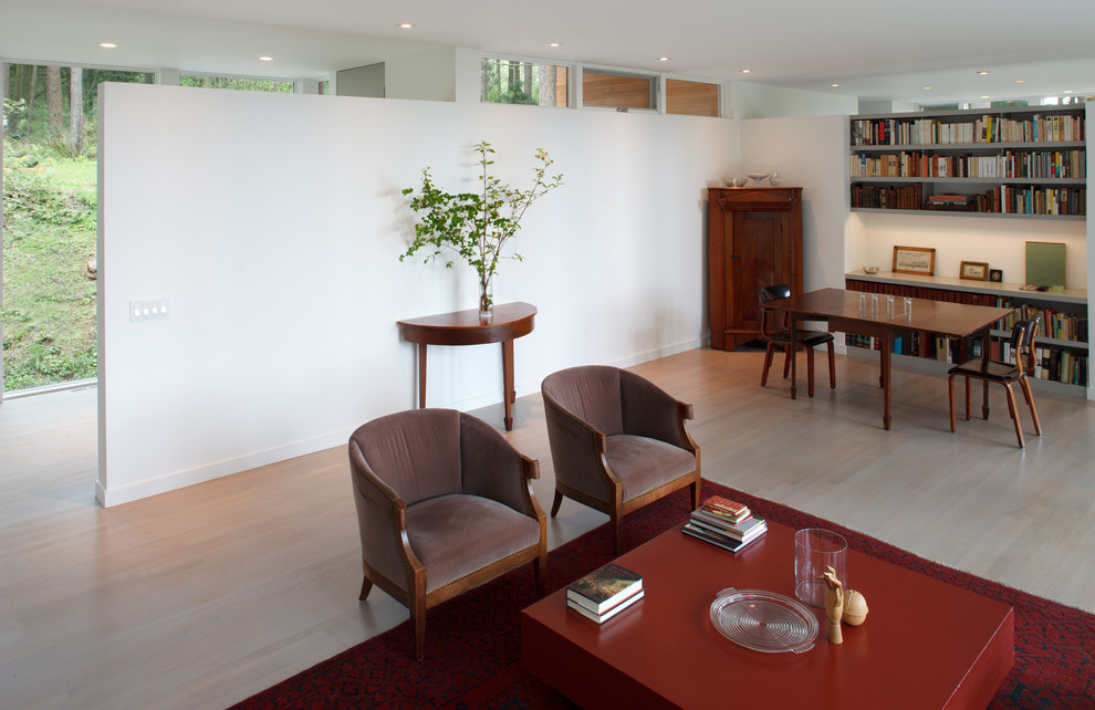 Пример оригинального дизайна: открытая гостиная комната среднего размера в современном стиле с белыми стенами, светлым паркетным полом, стандартным камином и фасадом камина из штукатурки без телевизора