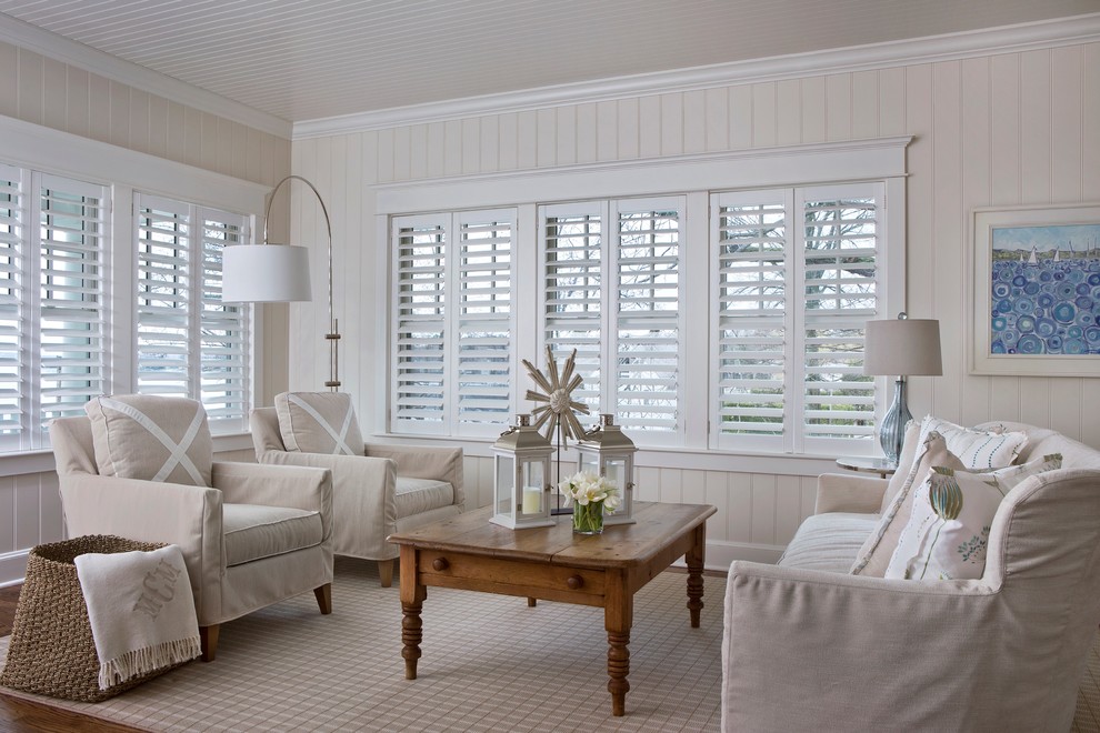 Imagen de salón abierto costero de tamaño medio con paredes beige y suelo de madera en tonos medios