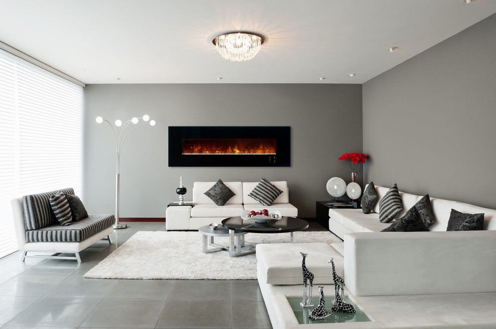 Medium sized contemporary living room in New York with beige walls, a hanging fireplace and beige floors.