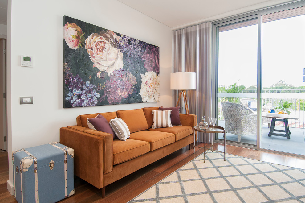 Idée de décoration pour un salon design avec un mur blanc, un sol en bois brun et un sol marron.