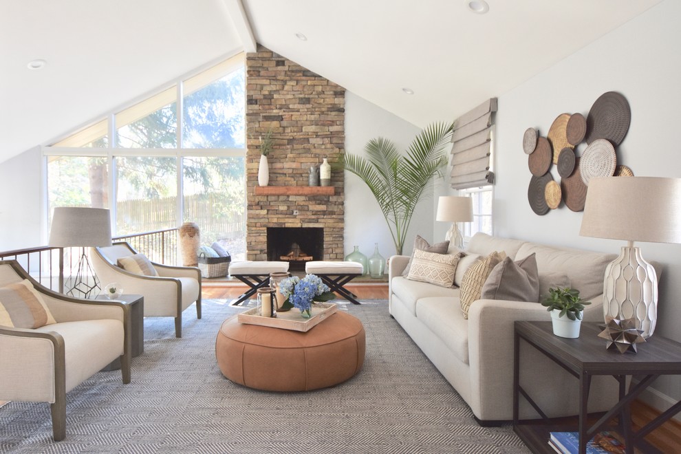 Inspiration for a transitional medium tone wood floor and brown floor living room remodel in DC Metro with white walls, a standard fireplace and a stone fireplace