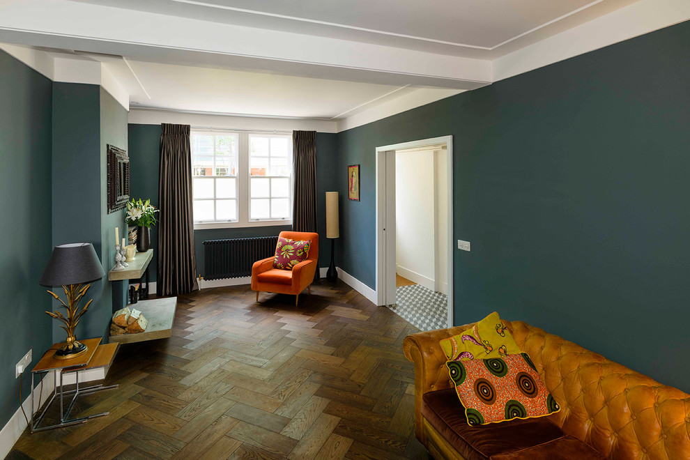 Example of a mid-sized trendy formal and enclosed medium tone wood floor living room design in London with green walls, no fireplace and no tv
