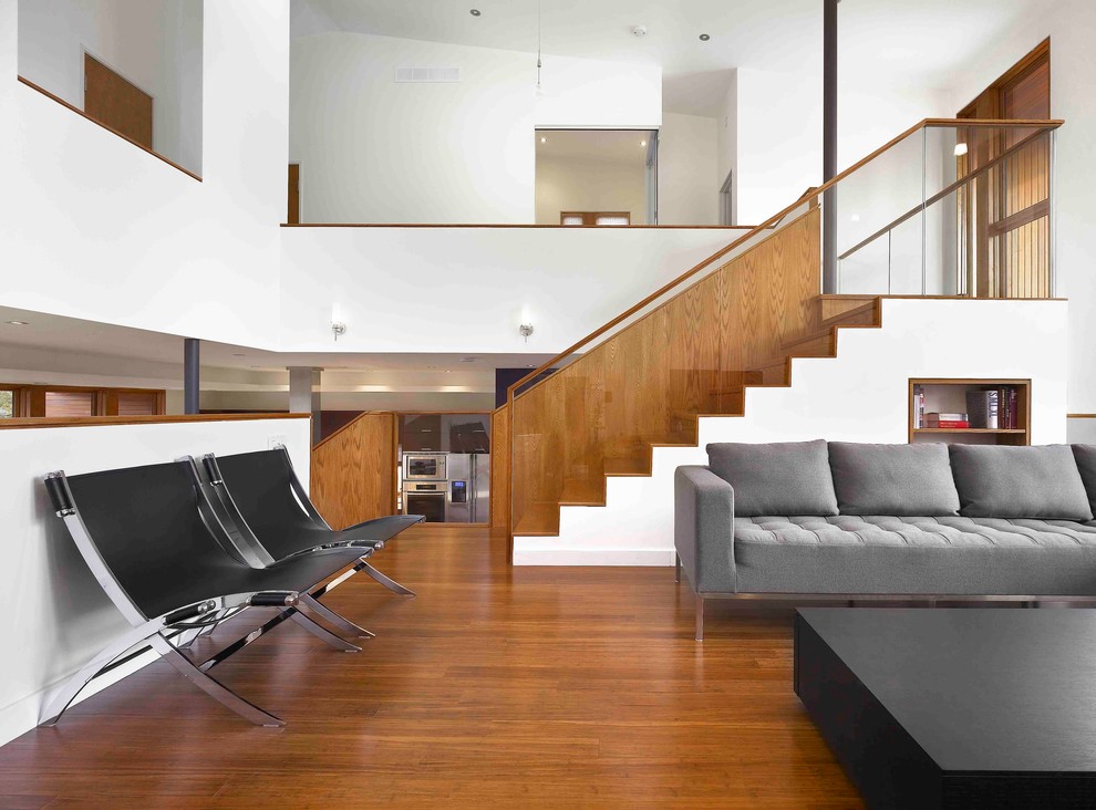 Large contemporary formal mezzanine living room in Toronto with white walls, bamboo flooring and brown floors.