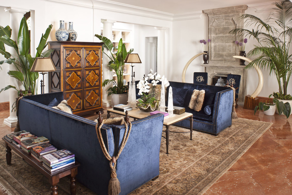 Стильный дизайн: гостиная комната в средиземноморском стиле с белыми стенами, полом из терракотовой плитки, стандартным камином и синим диваном - последний тренд