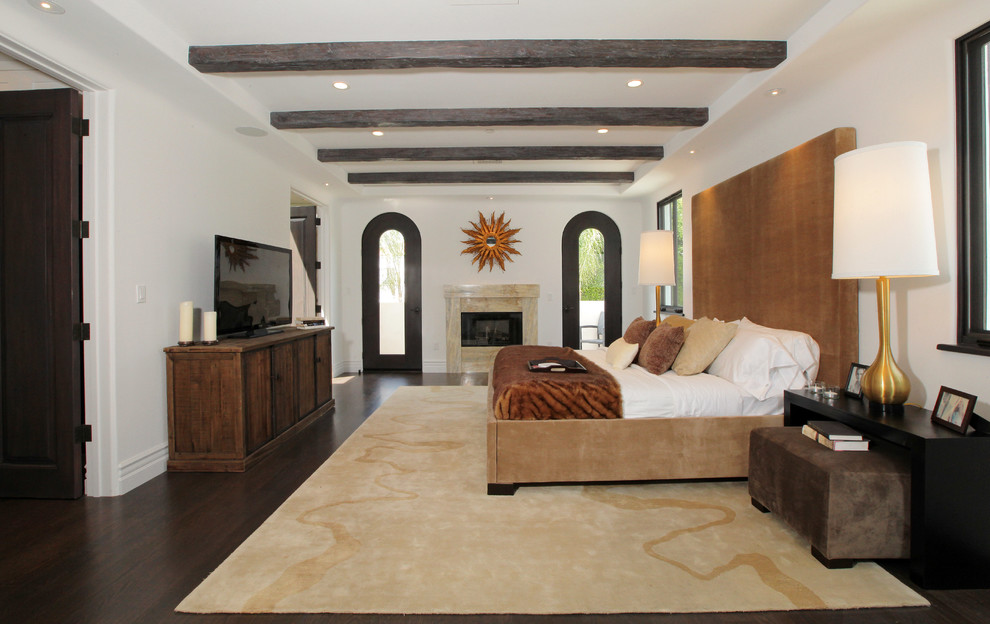 На фото: спальня среднего размера в современном стиле с белыми стенами, светлым паркетным полом, стандартным камином и фасадом камина из дерева