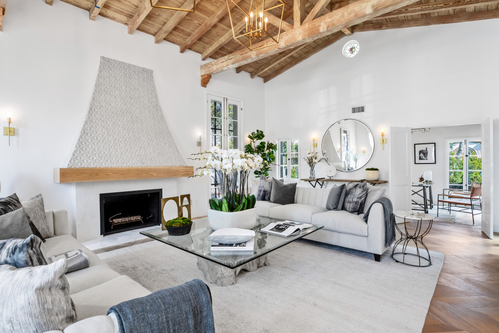 Klassisches Wohnzimmer mit weißer Wandfarbe, braunem Holzboden, Kamin, braunem Boden und freigelegten Dachbalken in Los Angeles