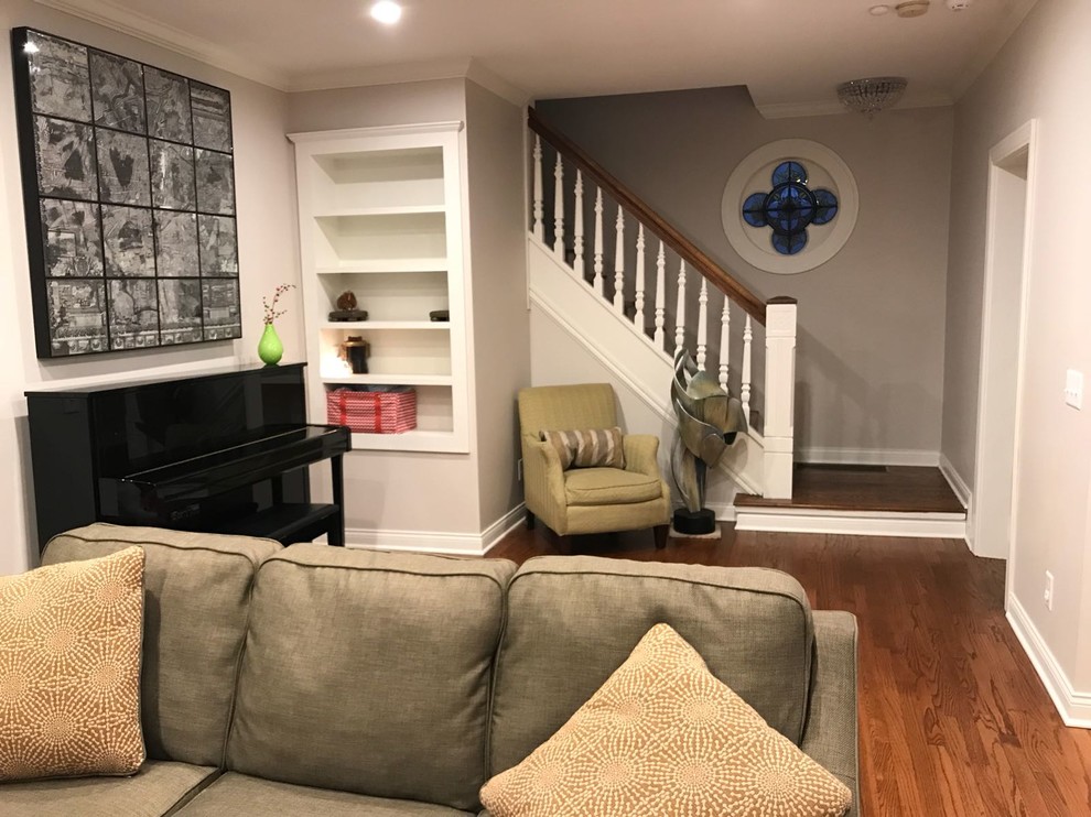 This is an example of a small classic enclosed living room in Columbus with grey walls, dark hardwood flooring, a standard fireplace, a wooden fireplace surround, a wall mounted tv and brown floors.