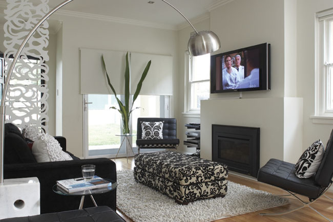 Idee per un piccolo soggiorno minimal aperto con pareti bianche, parquet chiaro, camino classico, cornice del camino in intonaco e TV a parete