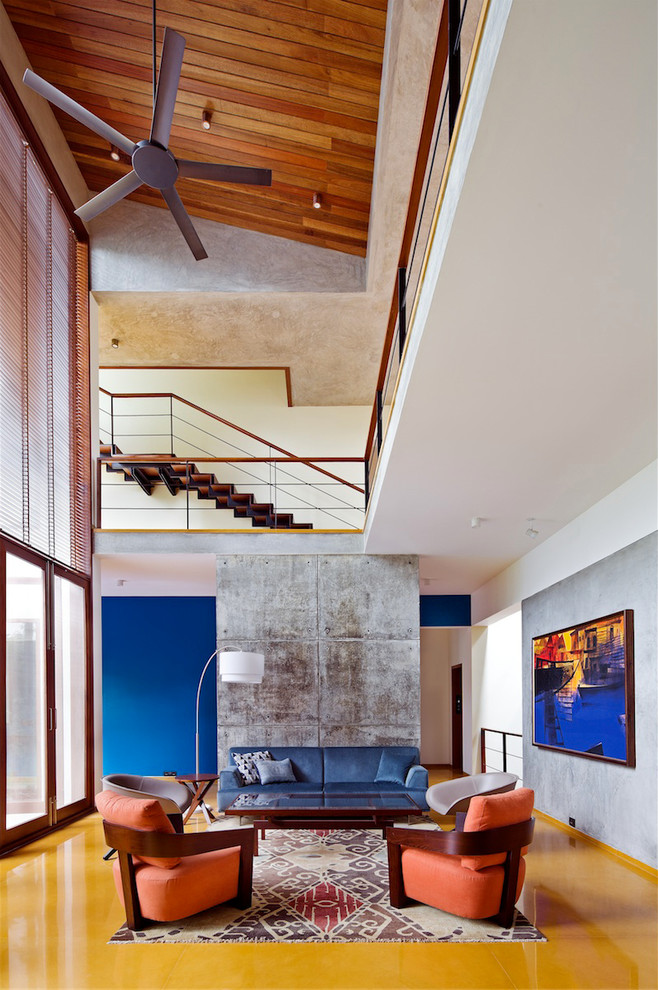 Стильный дизайн: изолированная гостиная комната в современном стиле с синими стенами и синим диваном - последний тренд