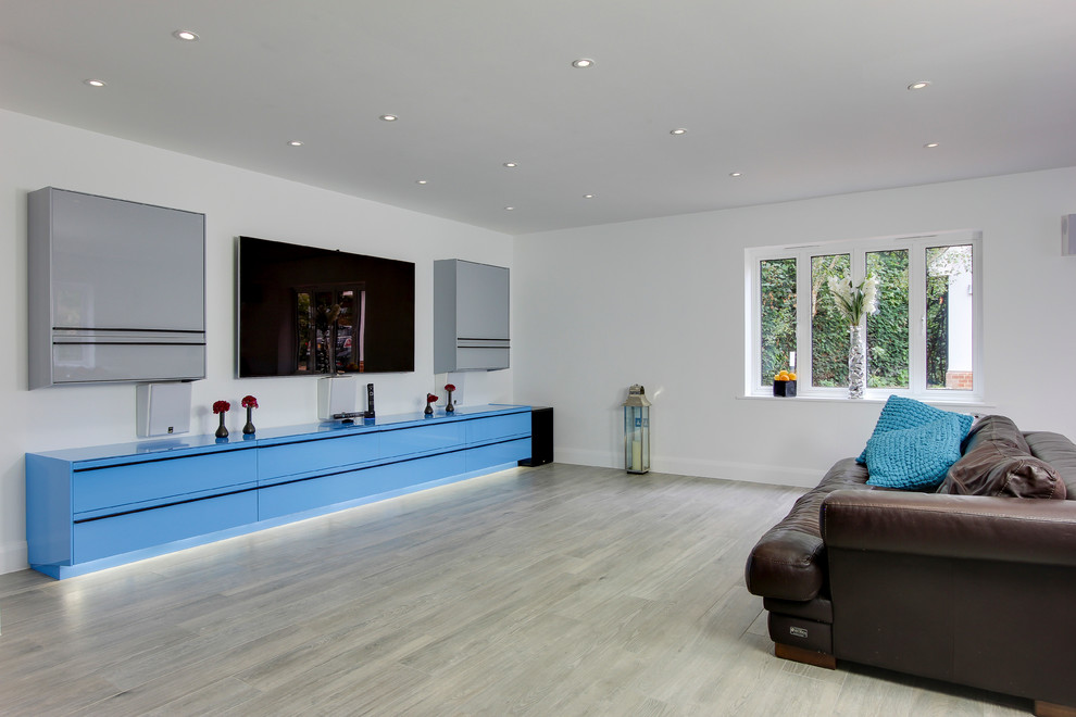 Modelo de salón contemporáneo sin chimenea con paredes blancas, suelo de baldosas de porcelana y televisor colgado en la pared