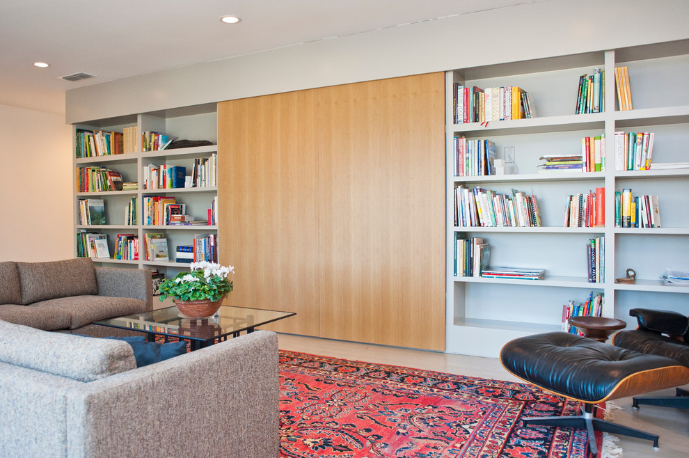 На фото: гостиная комната в современном стиле с с книжными шкафами и полками без камина с