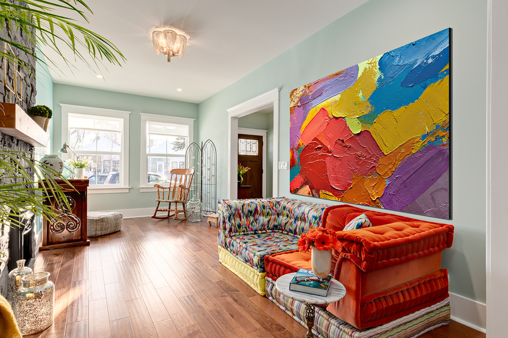 Foto di un piccolo soggiorno stile shabby chiuso con pareti blu, pavimento in legno massello medio, stufa a legna, cornice del camino in pietra e pavimento marrone